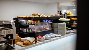 Ein Frühstücksbuffet mit verschiedenen Speisen und einer Kaffeemaschine.
