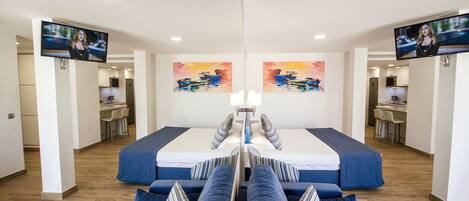 A mirrored room with a central bed, two TVs, and artwork on the walls.