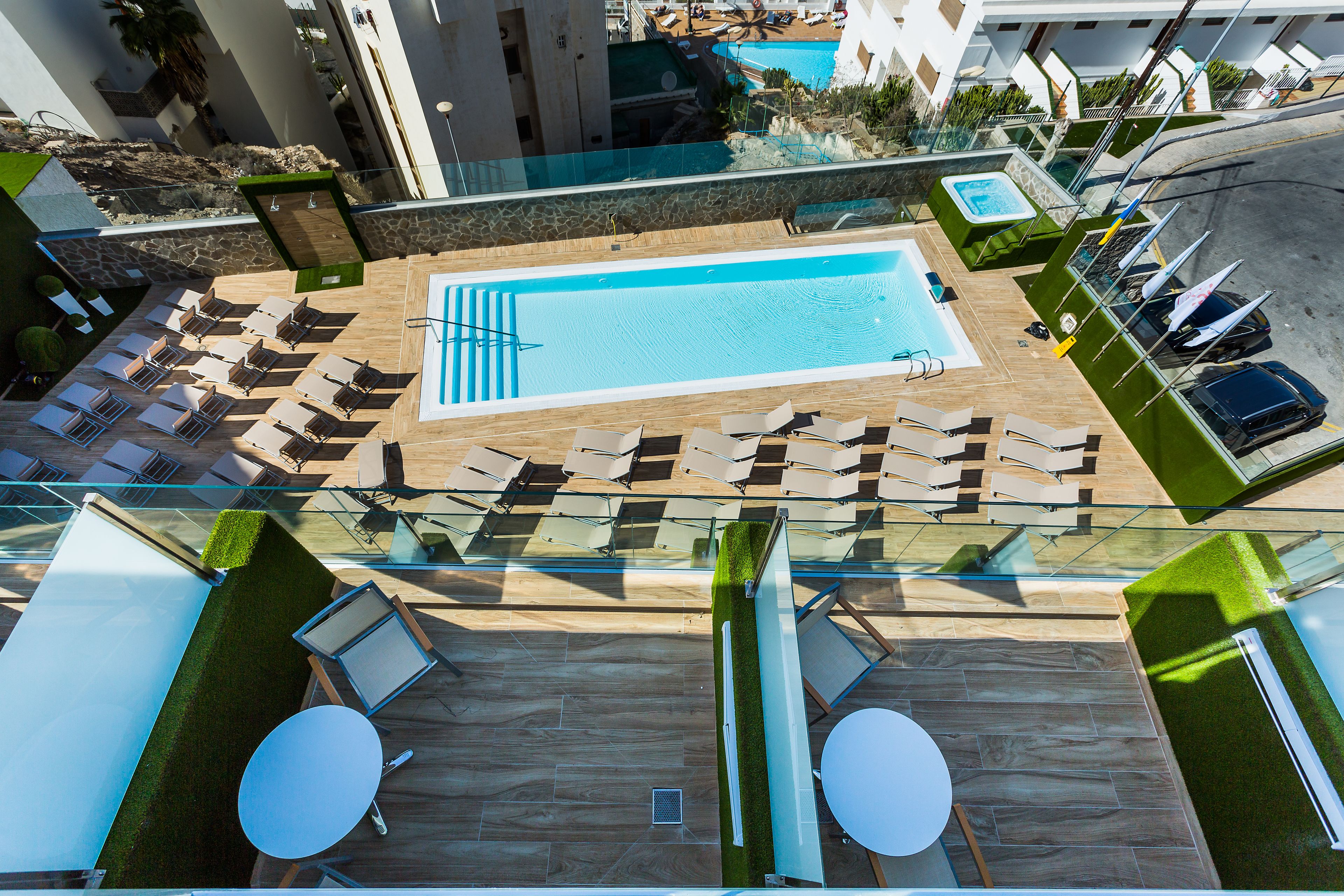 Un área de piscina en la azotea con sillones de descanso y una piscina.