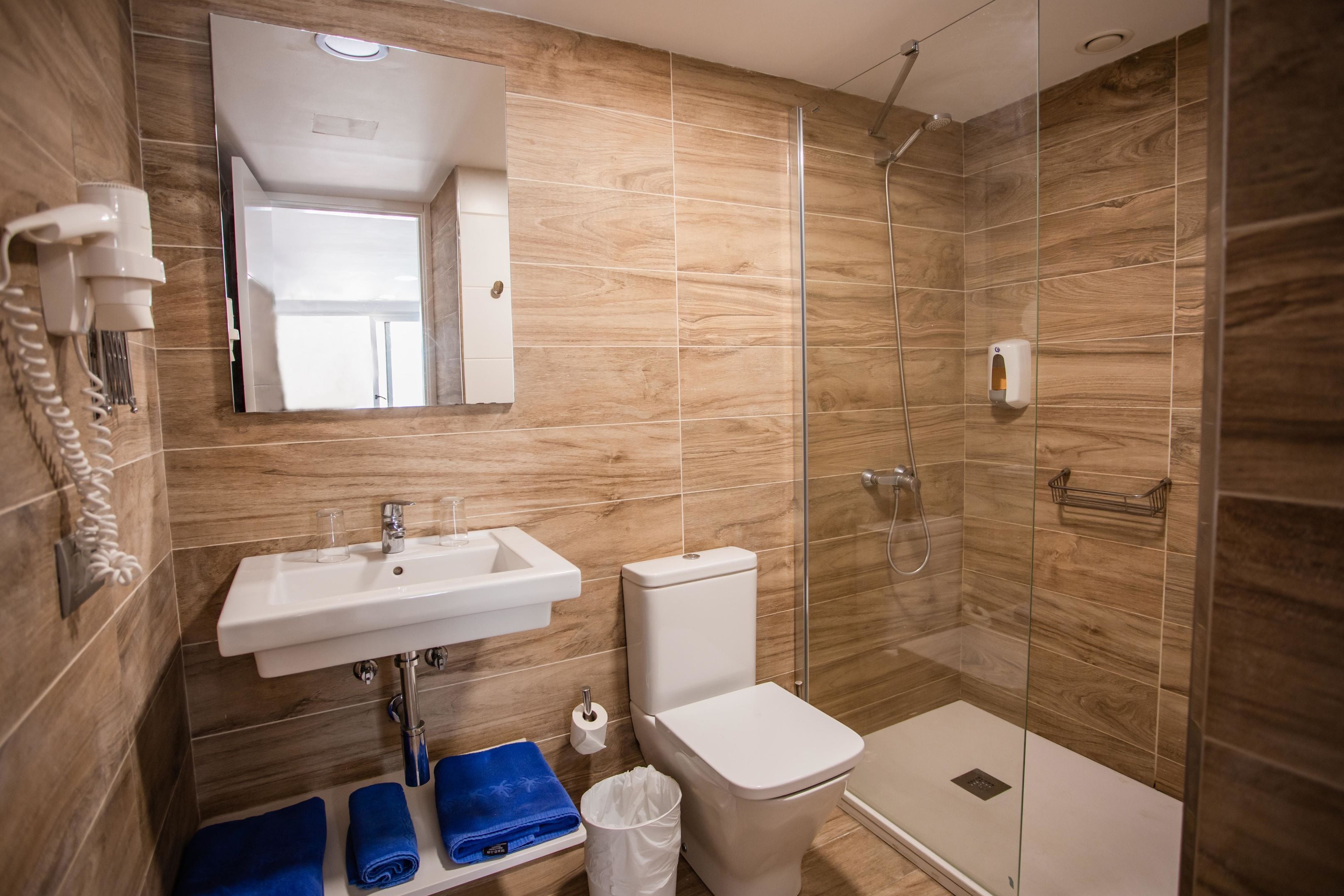 A modern bathroom with a sink, toilet, and glass-enclosed shower.