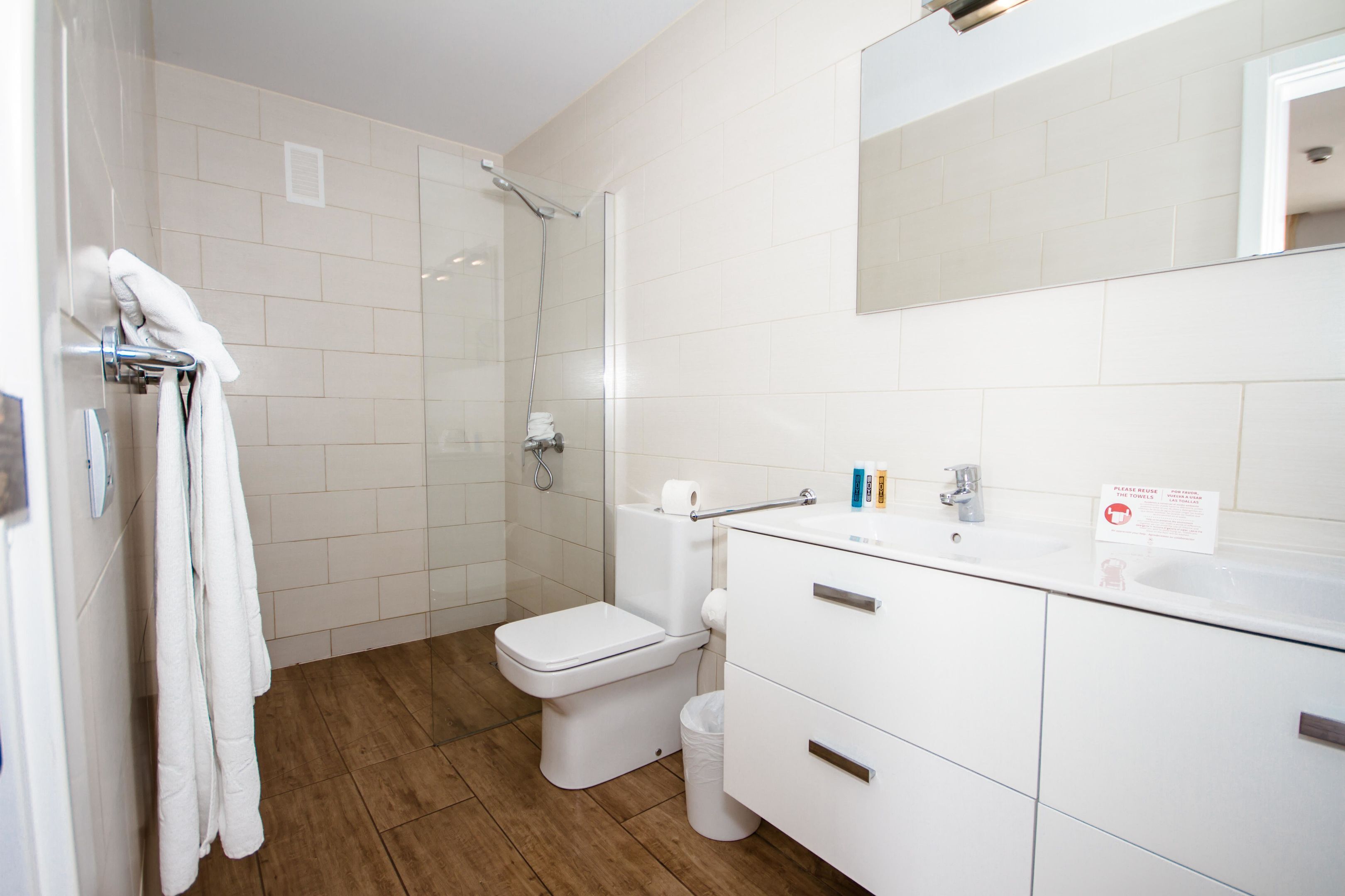 Un baño moderno con ducha, inodoro y lavamanos.