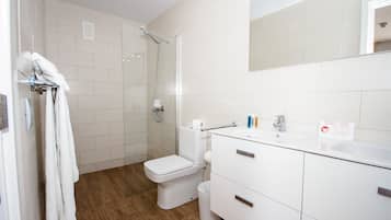 Un baño moderno con ducha, inodoro y lavamanos.