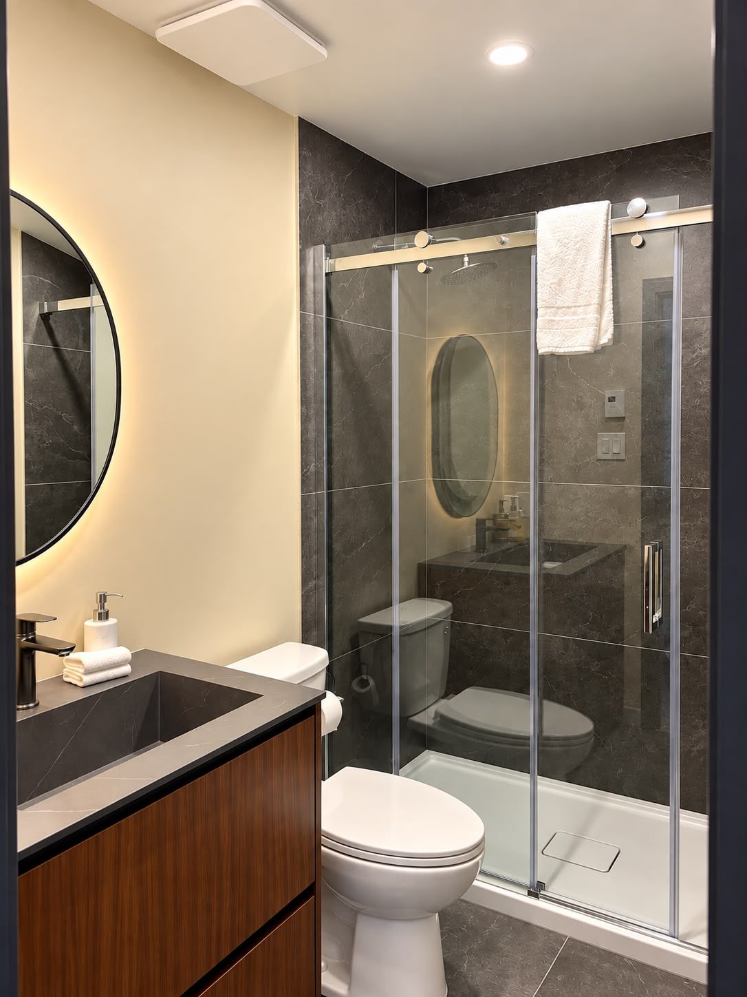 Un bagno moderno con doccia a vetro, un water e un lavabo con specchio.