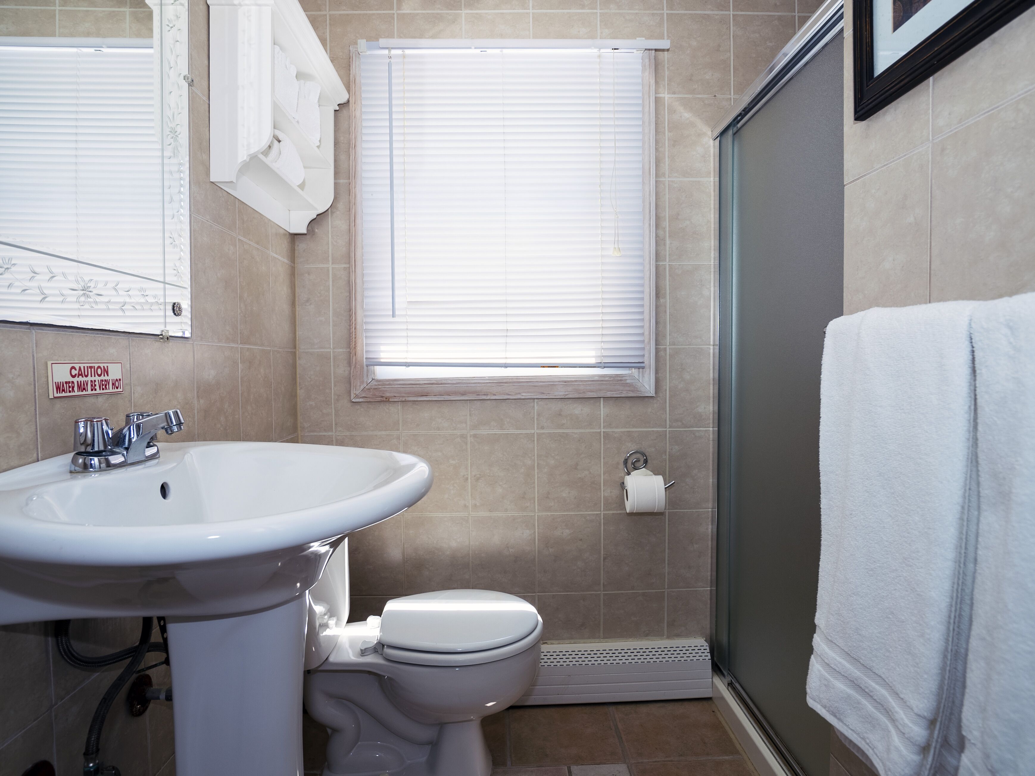 Un baño con lavamanos, inodoro y ducha.