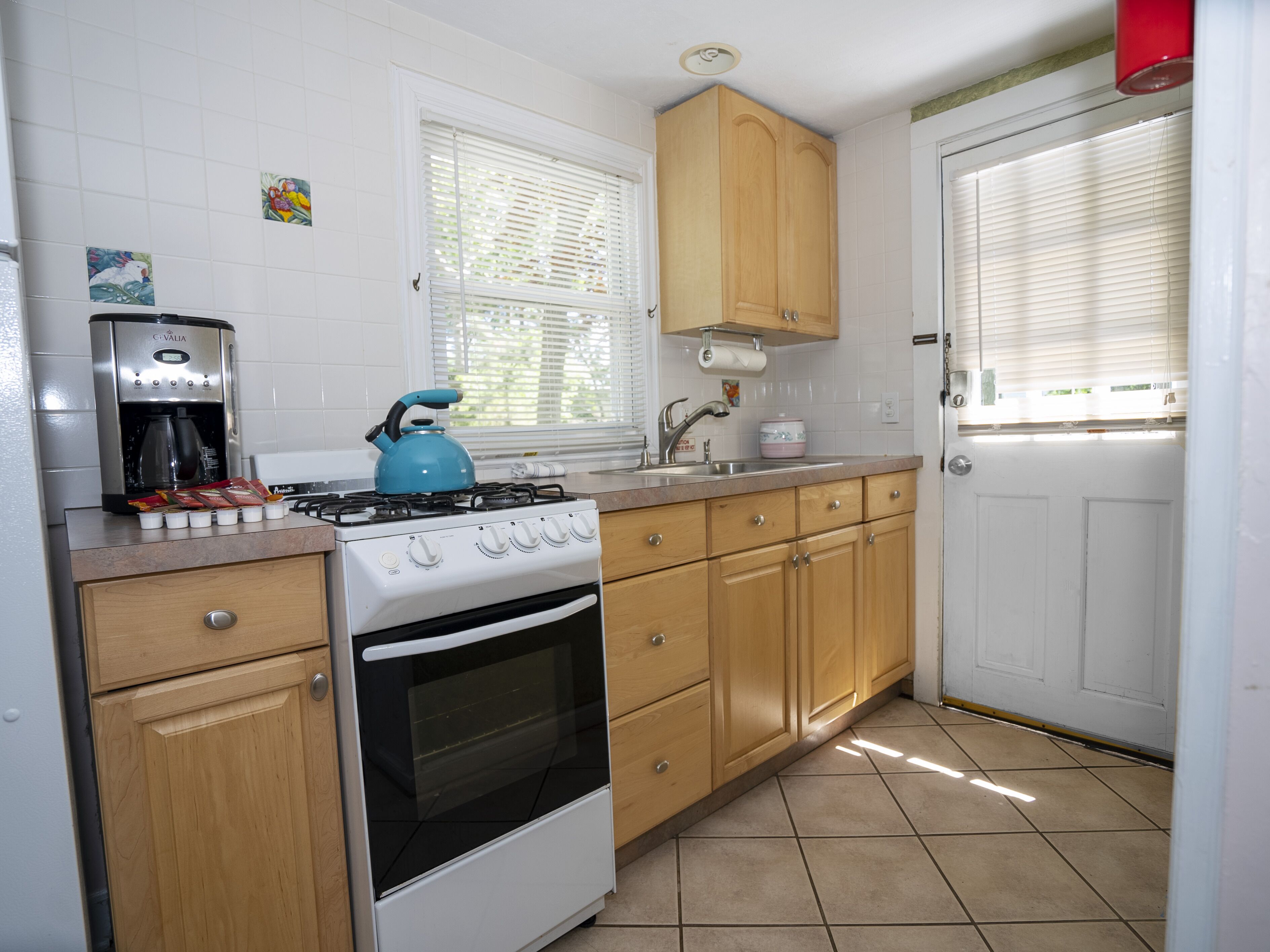 A kitchen with a stove, oven, and coffee maker.