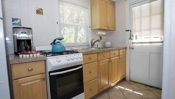 A kitchen with a stove, oven, and coffee maker.