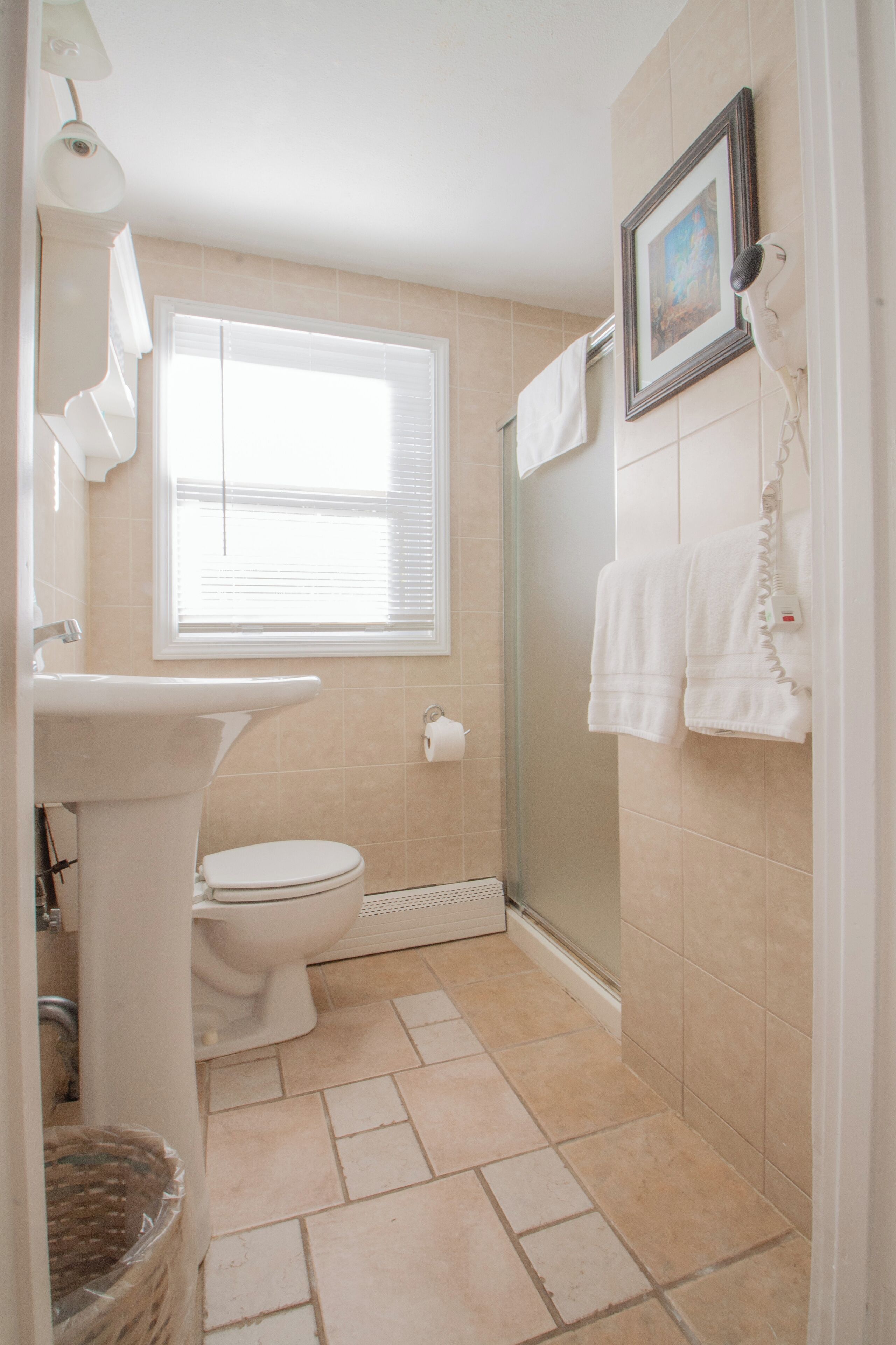A bathroom with a toilet, sink, and shower.