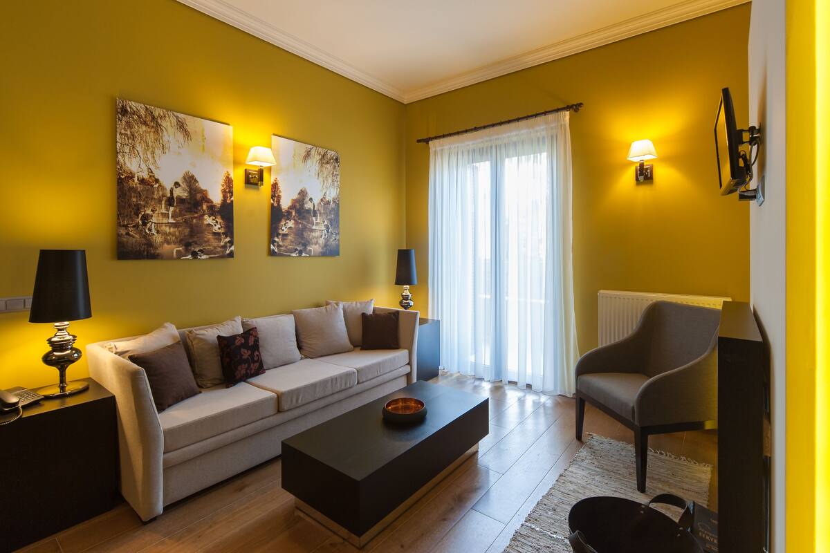 A living room with a sofa, a coffee table, a chair, and two wall-mounted lamps.