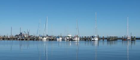 A marina with several sailboats docked at wooden piers.