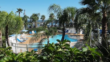 Una piscina al aire libre, sombrillas, sillones reclinables de piscina