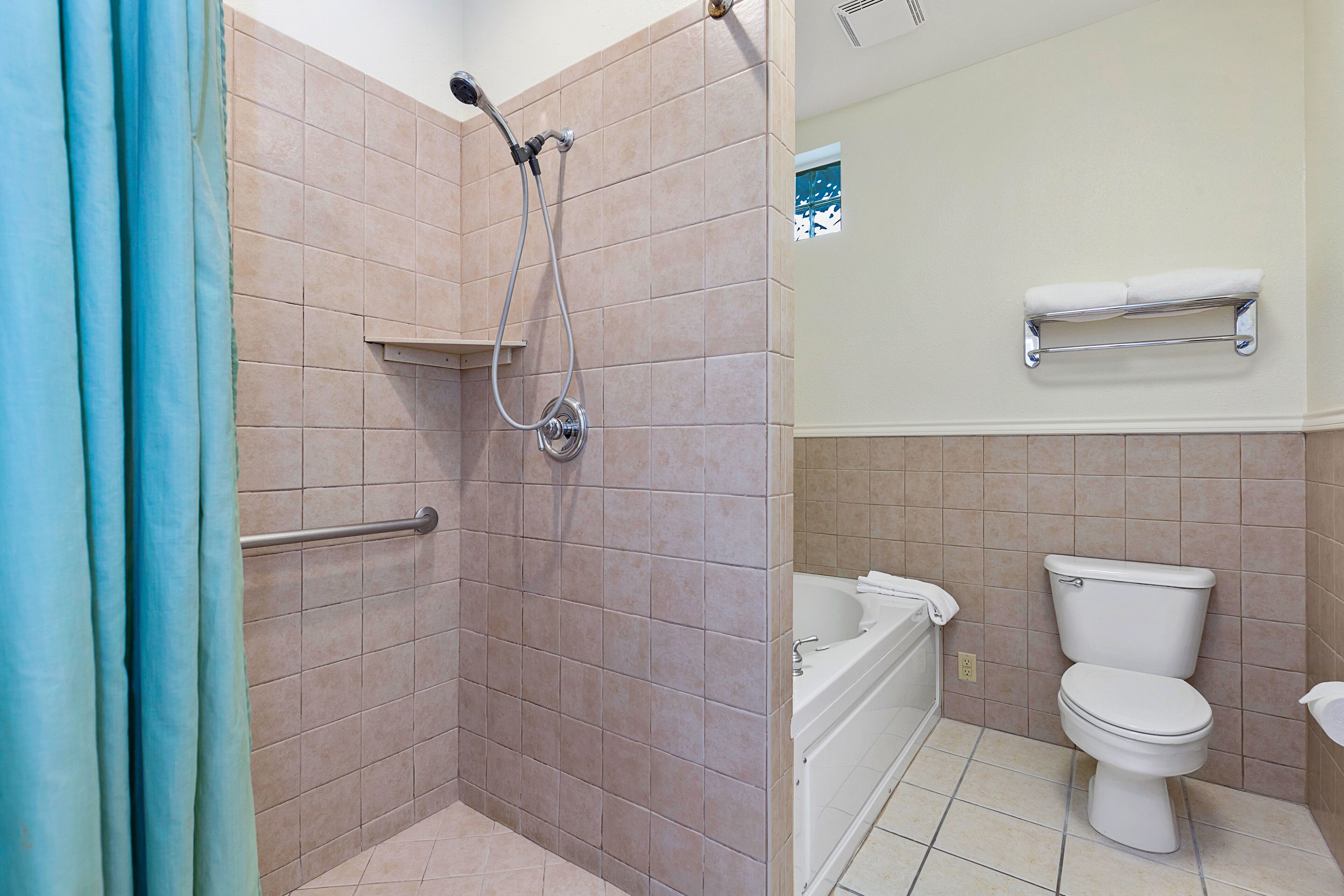 A bathroom with a shower, toilet, and bathtub.