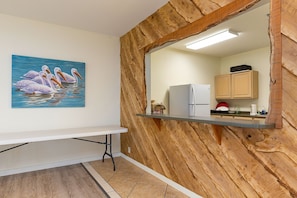 A kitchen with wooden wall paneling, a white refrigerator, and a countertop with a sink.