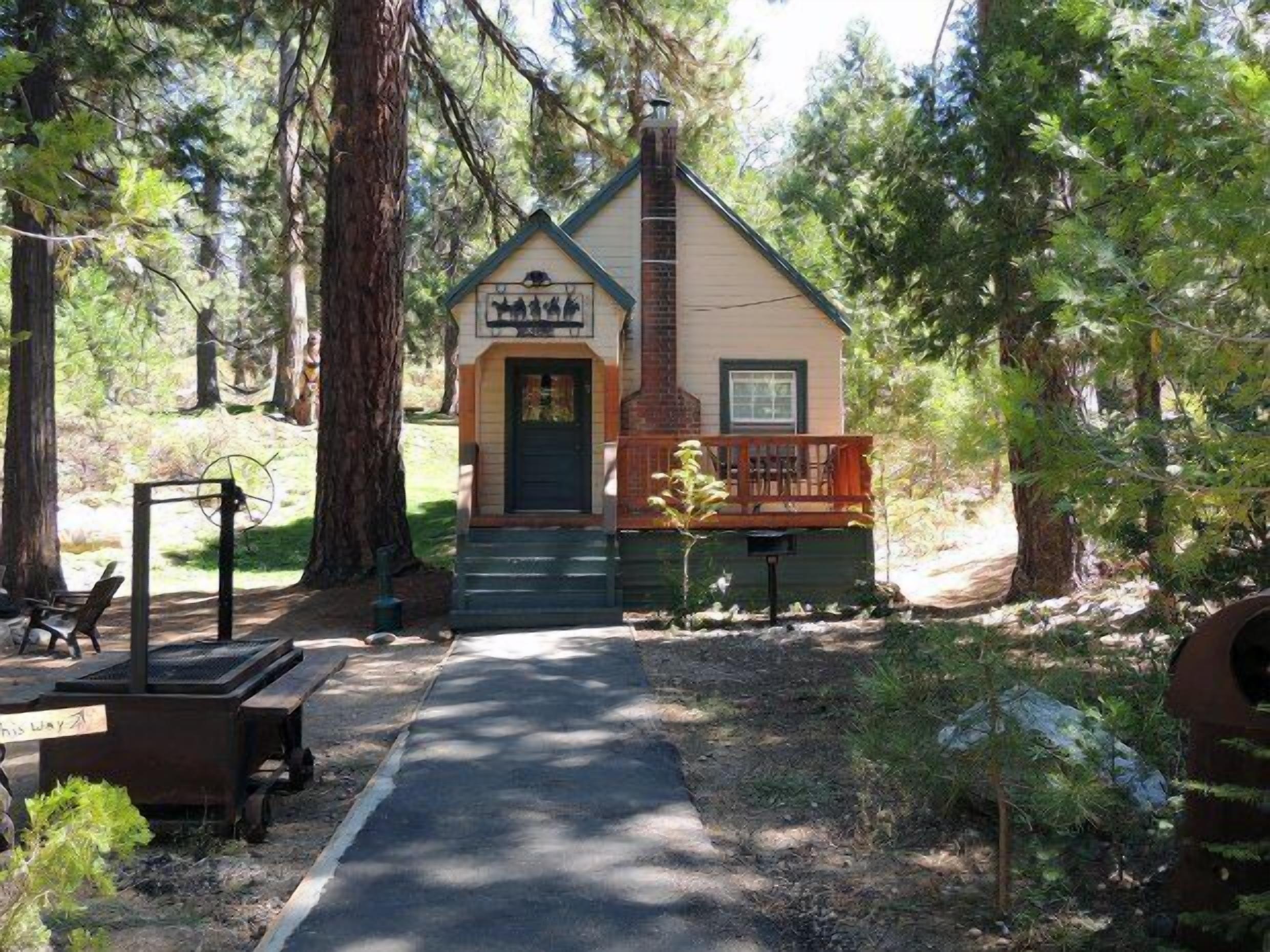A cabin with a porch, a chimney, and a sign with animal silhouettes.