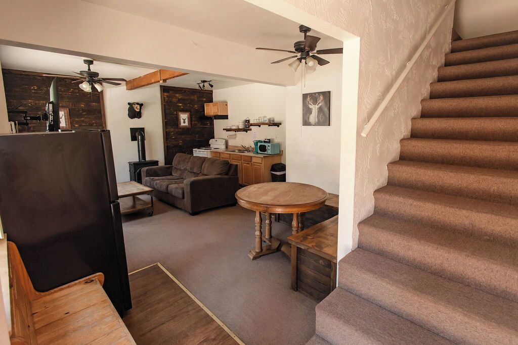 Una sala de estar acogedora con chimenea, una mesa de comedor y una escalera.