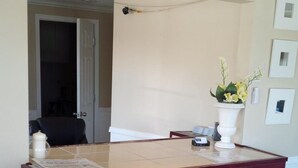 A reception desk with a dark wood finish, a white vase with flowers, and a black rug on the floor. - Holiday Lodge (Port Angeles)