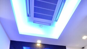 An elevator with a modern design, a dark marble wall, and a blue-lit ceiling. - Cathay Hotel (Kota Kinabalu)