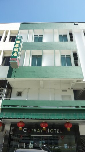 A hotel with a green awning and a sign indicating it is Cathay Hotel.