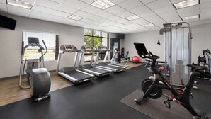 Ein Fitnessraum mit Laufbändern, Crosstrainern und einem stationären Fahrrad.