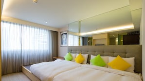 A hotel room with a large bed, a bedside table, a mirror, and a window with curtains. - The Crystal Inn Sun Moon Lake (Yuchi)