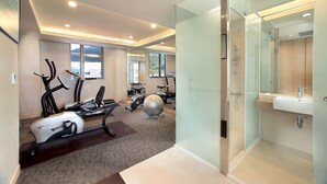 A modern hotel room with a gym area, including exercise equipment and a large mirror. - The Crystal Inn Sun Moon Lake (Yuchi)