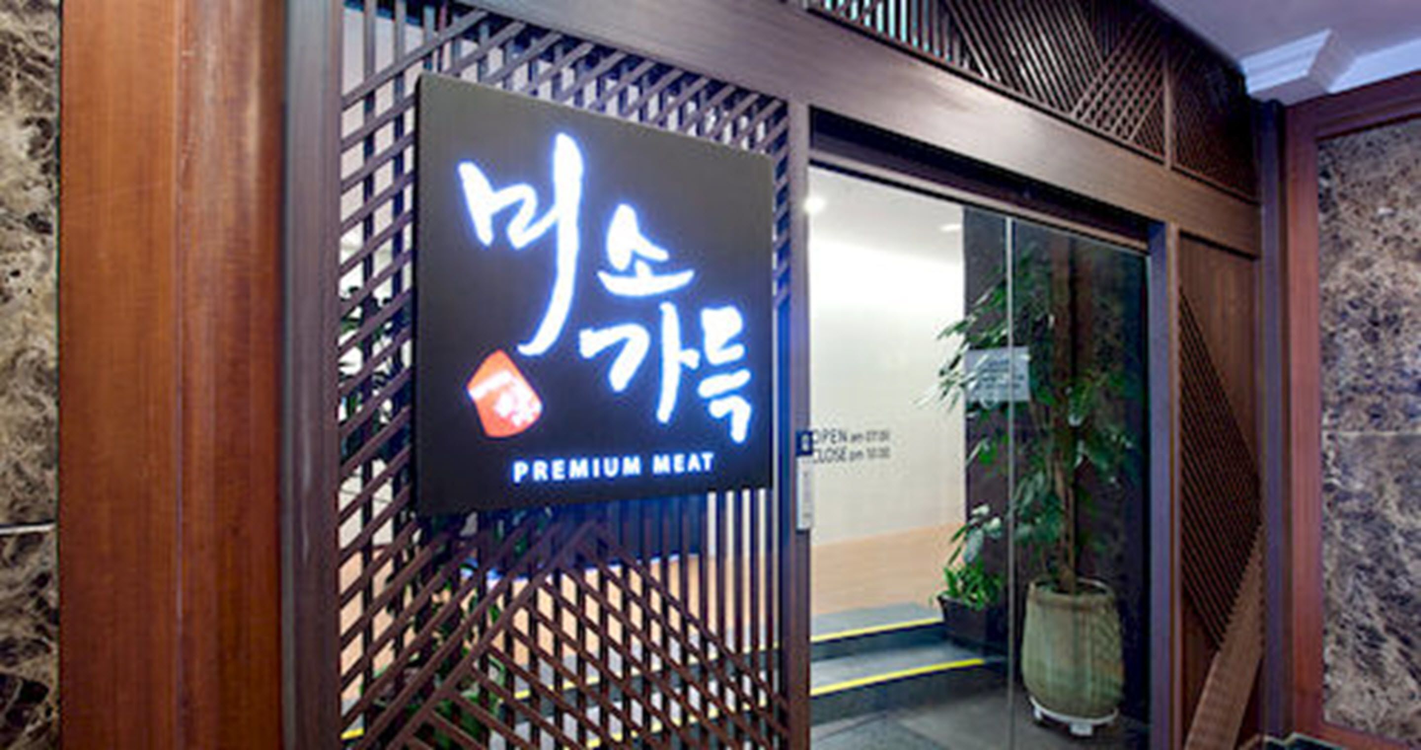 Een bord met Koreaanse karakters en de tekst 'PREMIUM MEAT', dat een restaurant of eetgelegenheid aangeeft.