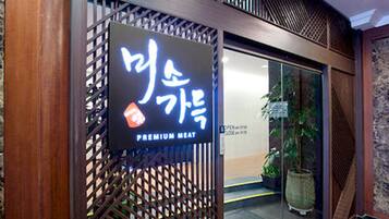 Een bord met Koreaanse karakters en de tekst 'PREMIUM MEAT', dat een restaurant of eetgelegenheid aangeeft.