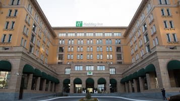 Welcome to the Holiday Inn, featuring a central entrance flanked by two wings with arched windows and a covered entrance.