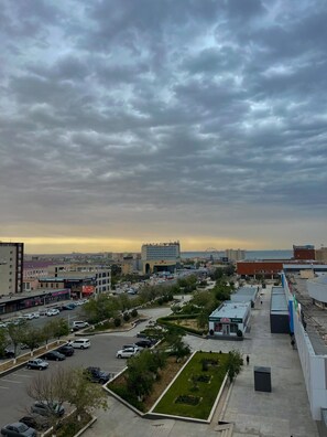 A parking lot with several cars, a few trees, and buildings in the background. - Holiday Inn Aktau by IHG (Aktau)