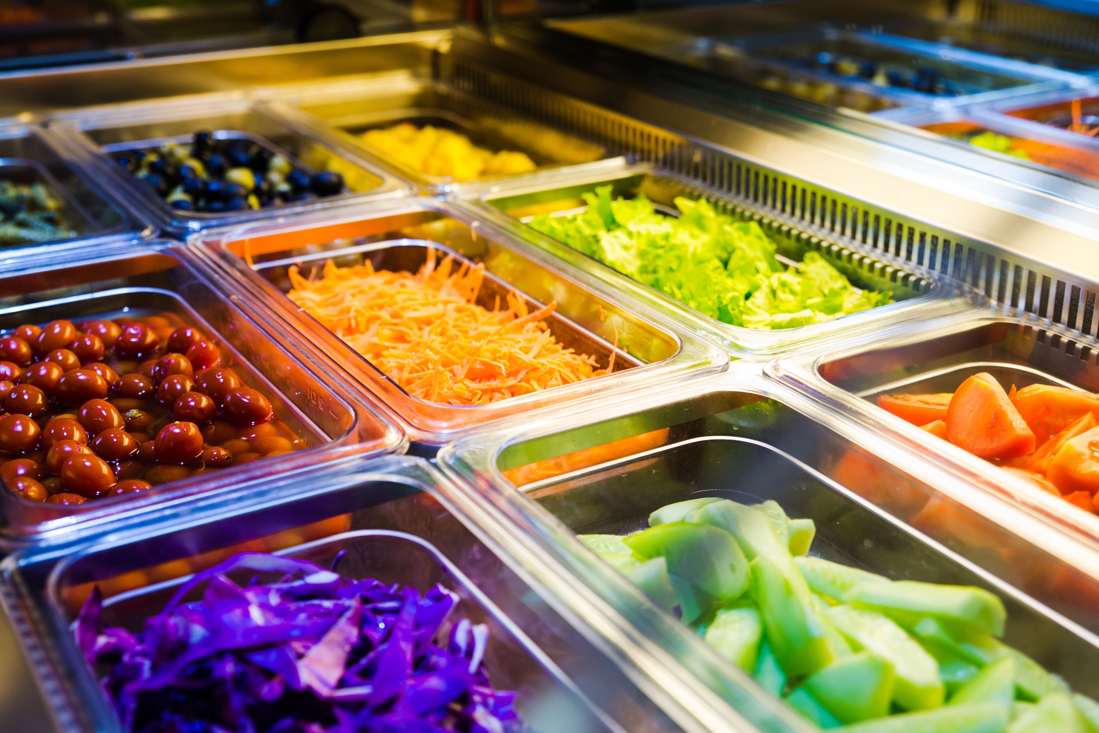 A buffet with various food items in separate containers.