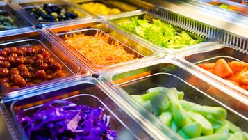 A buffet with various food items in separate containers.