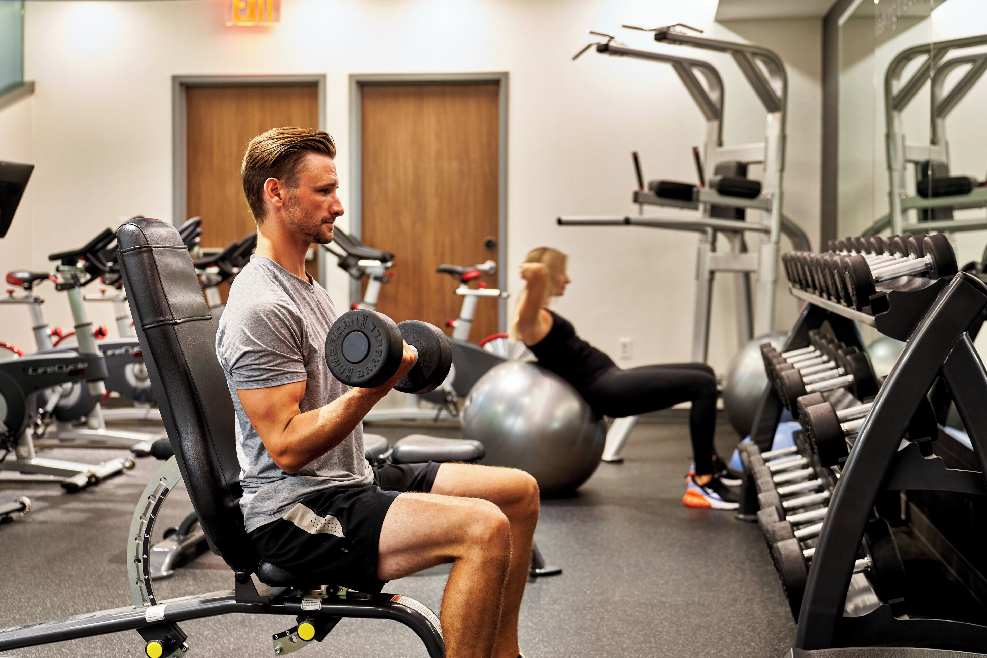 A gym with exercise equipment, including a bench and dumbbells.