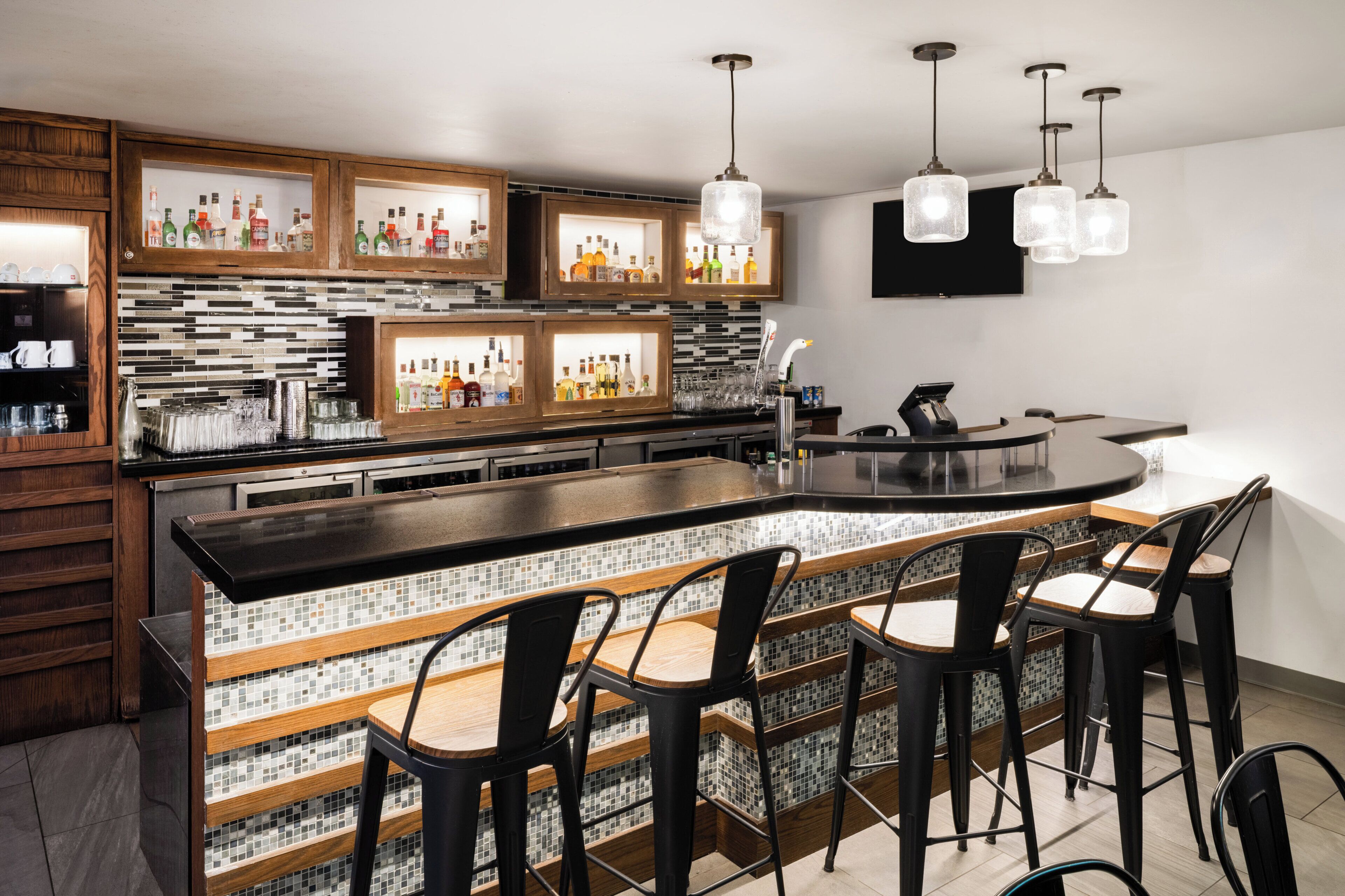 Una cocina moderna con barra, armarios de madera y salpicadero de azulejos.