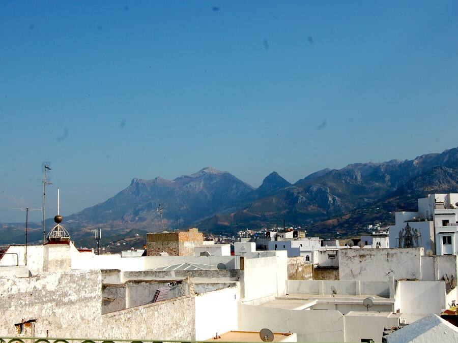 Vista de un paisaje montañoso con edificios en primer plano.