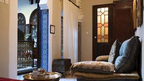 A traditional room with a sofa, a tray with teaware, and a decorative door.