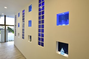 A hallway with multiple small windows and a large window with a view of the outside.