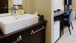 A modern bathroom with a large sink, mirror, and a desk with a chair. - Community & Spa Naha Central Hotel (Naha)