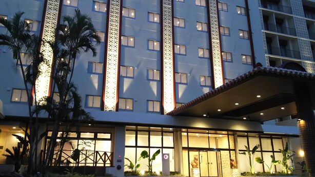 A hotel with multiple floors, large windows, and a well-lit entrance. - Community & Spa Naha Central Hotel (Naha)