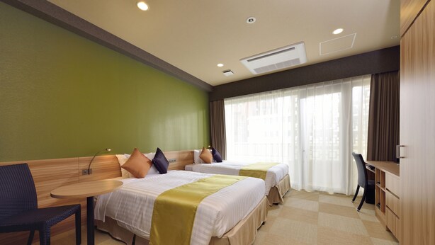 A hotel room with two beds, a desk, a chair, and a large window with curtains. - Community & Spa Naha Central Hotel (Naha)