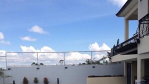 Une piscine avec un mur blanc et un balcon.