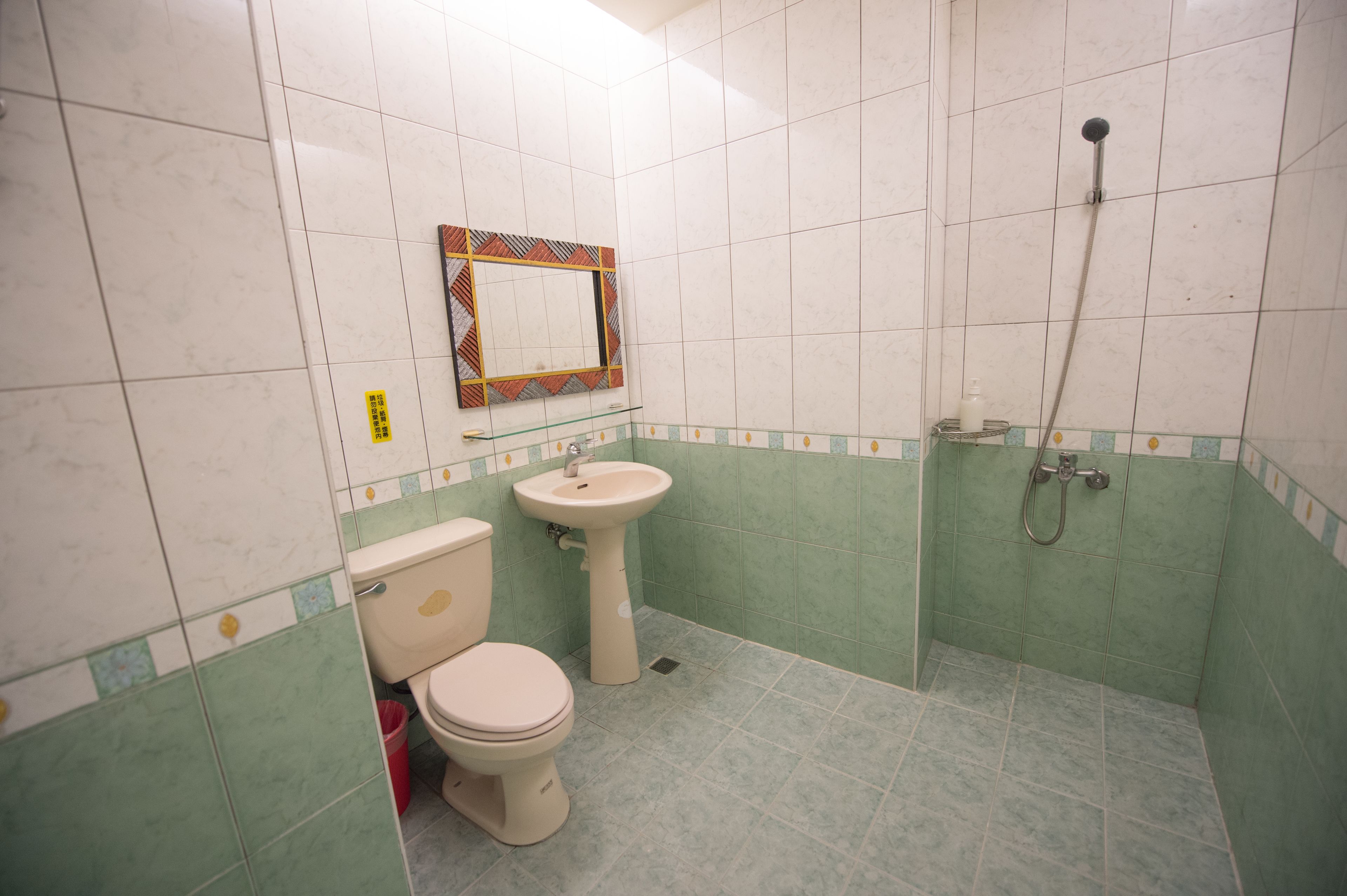 A bathroom with a toilet, sink, and shower.
