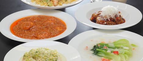 A table with various dishes including rice, soup, and a meat dish.