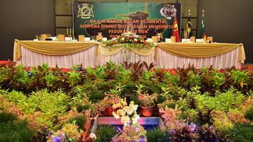 A decorated event table with a banner, trophies, and a floral arrangement.