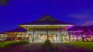 A large, two-story building with a prominent triangular roof and a covered outdoor seating area.