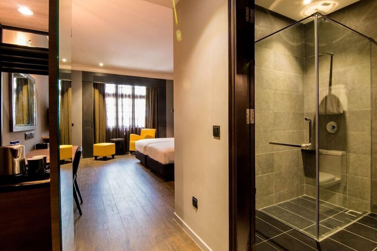 Een hotelkamer met een bed, een bureau, een stoel en een douche.