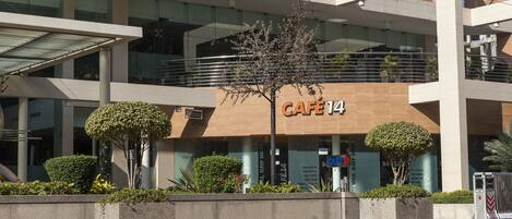 A modern building with a cafe named "CAFE 14" on the ground floor.