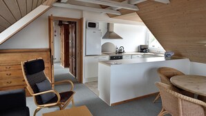 Una cucina moderna con isola centrale, mobili in legno e zona pranzo con sedie in vimini.
