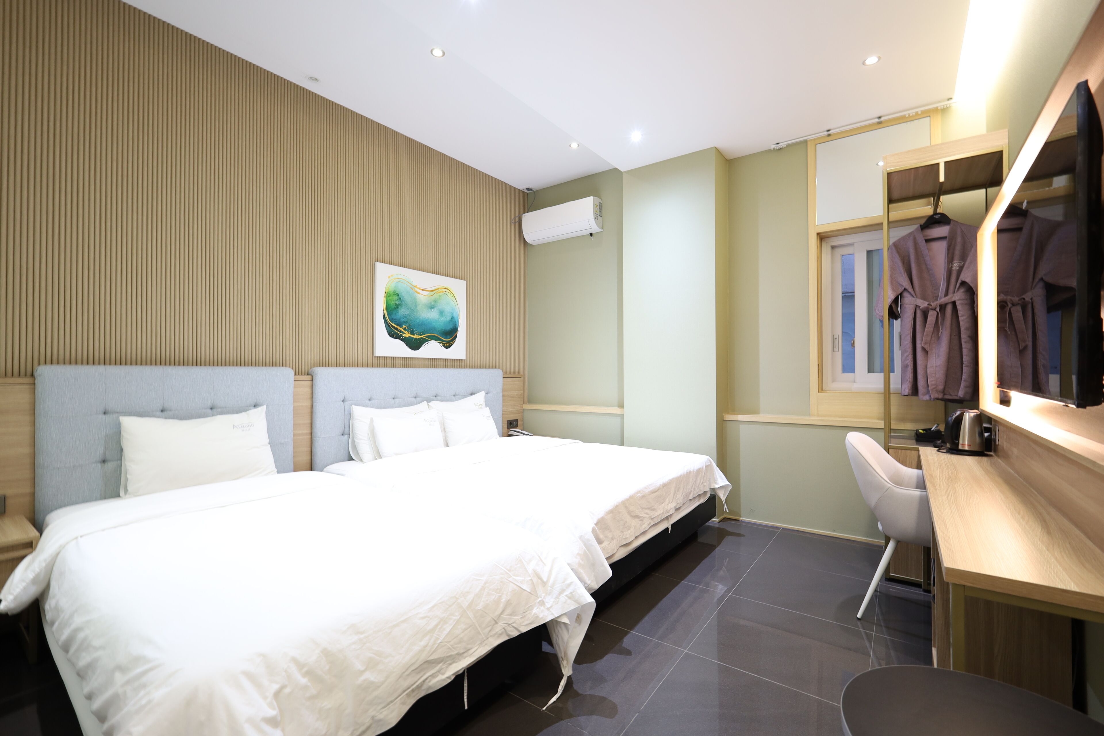 A modern hotel room with a large bed, a desk, and a chair.