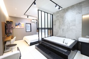 A modern hotel room with a large bathtub, a separate shower area, a seating area with a table and chairs, and a wardrobe. - Hotel Almond Busan Station (Busan)