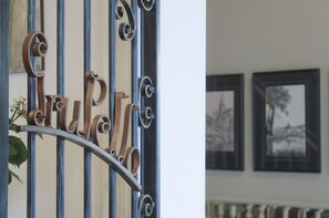 A wrought iron gate with the word "GRUPPI" and a plant beside it.