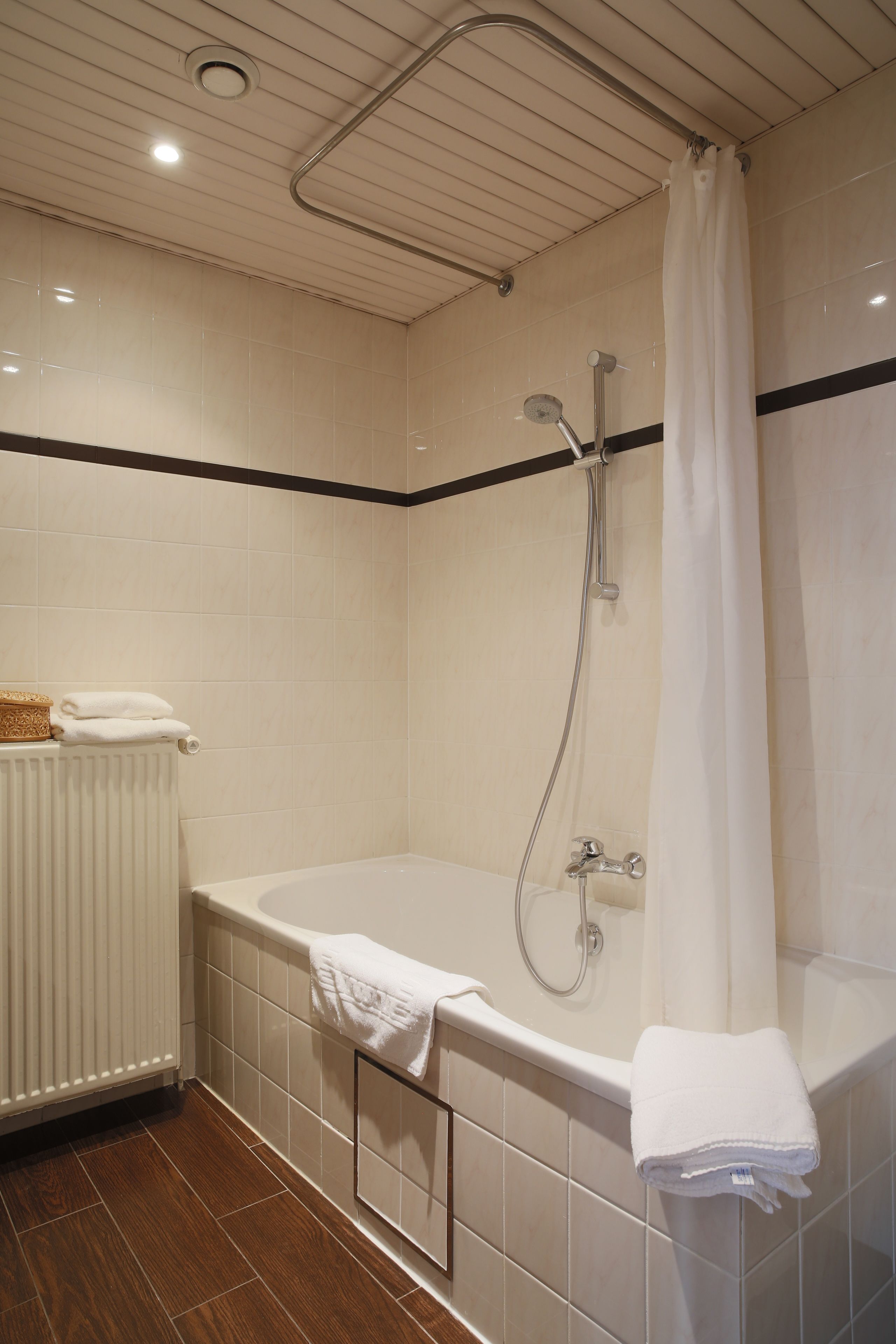 Une salle de bain moderne équipée d’une baignoire, d’une douche et d’un porte-serviettes.